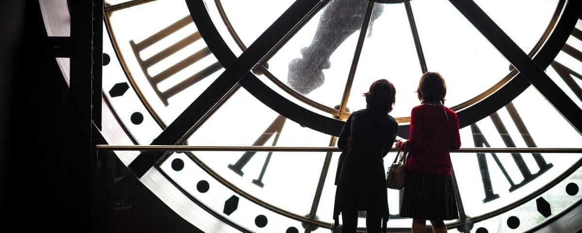 Image of a clock with people standing in front of it