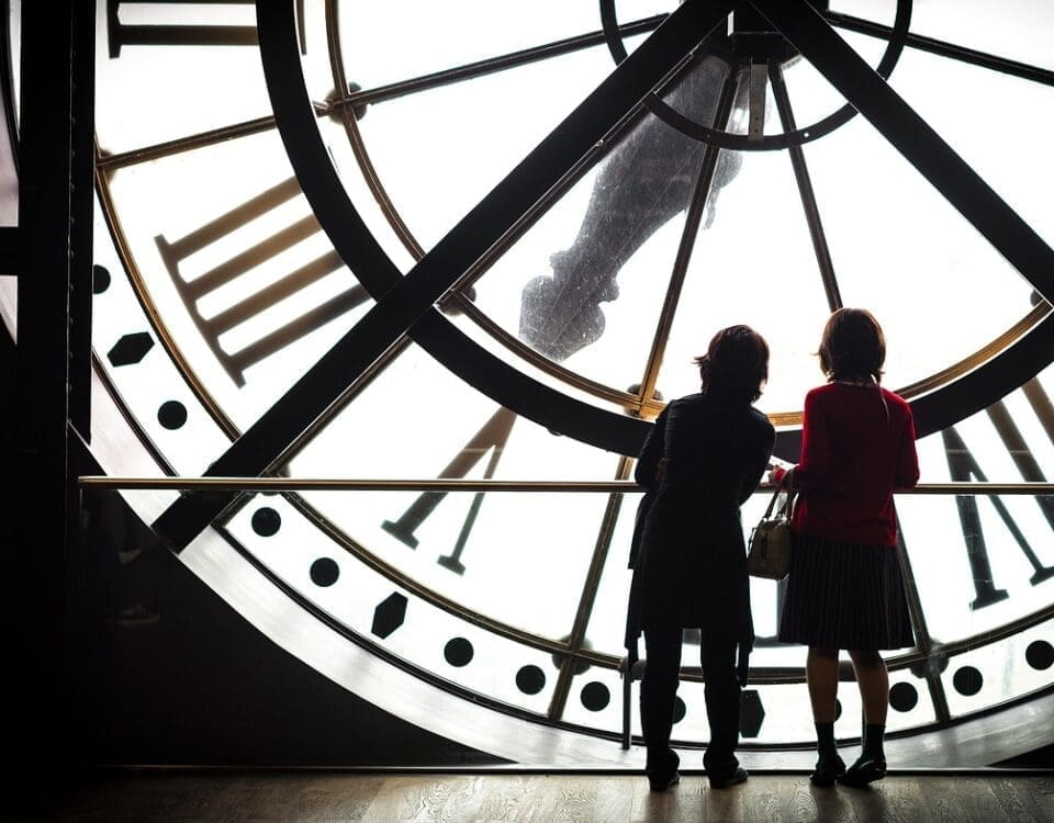 Image of a clock with people standing in front of it