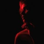 Image of a woman with red light shining on her