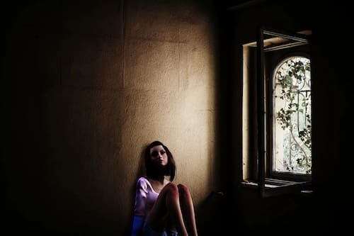Image of a lonely girl sitting in a room by herself